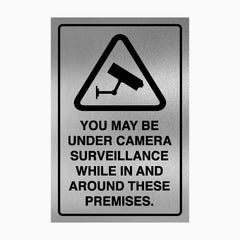 YOU MAY BE UNDER CAMERA SURVEILLANCE WHILE IN AND AROUND THESE PREMISES SIGN